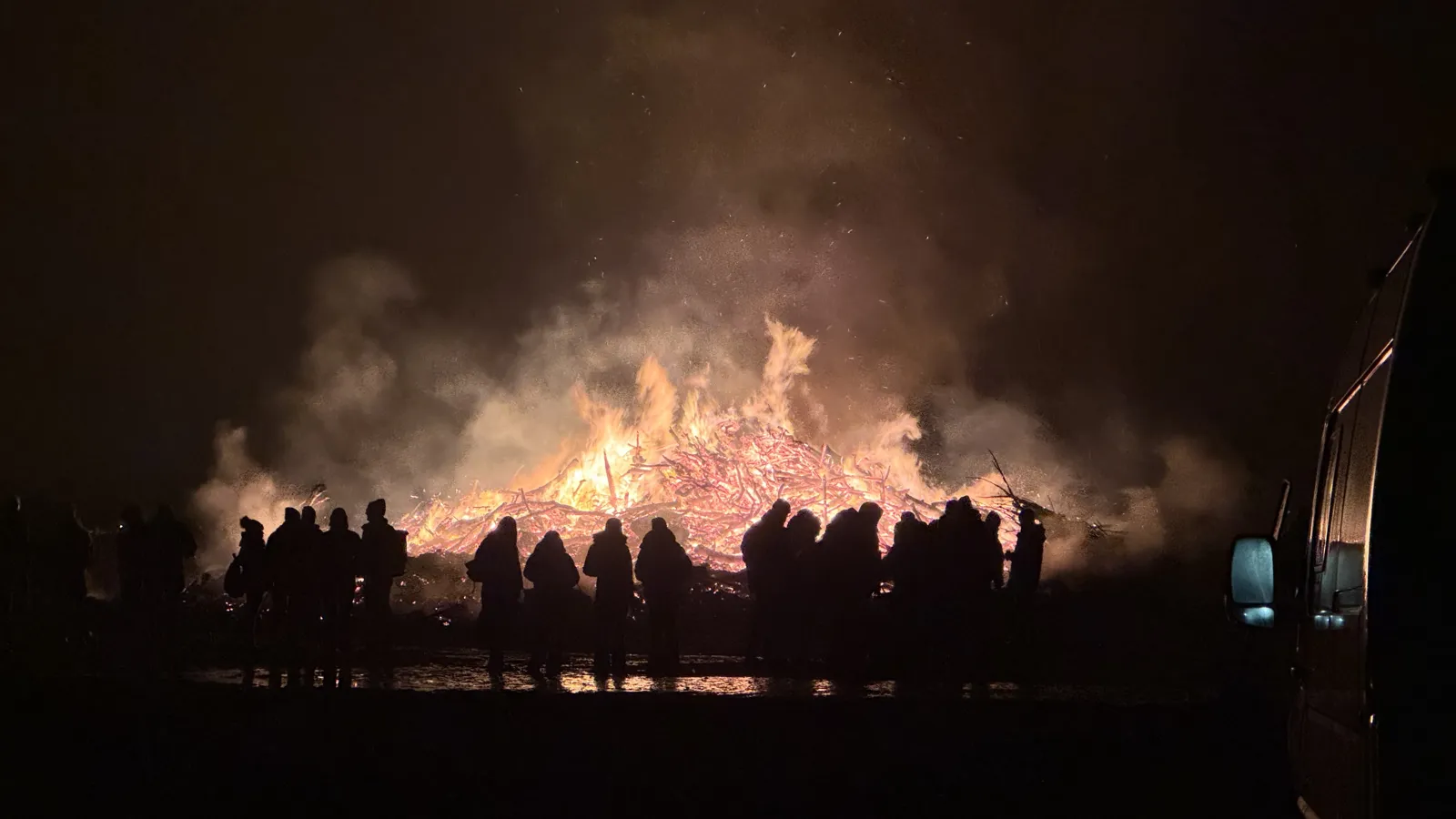 R.SH Biikebrennen auf Sylt bei Nacht: Zuschauer als Silhouetten vor dem Biikefeuer